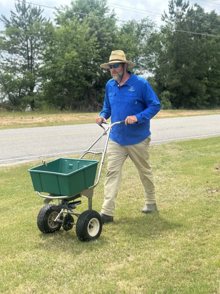 Carolina Green Treatments technician applying fertilizer to a residential lawn in the CSRA